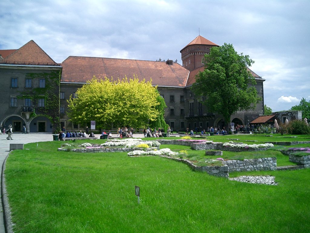 a large building with a lawn and a large building with a tower