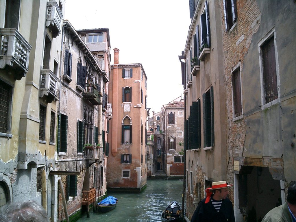 a canal between buildings with boats