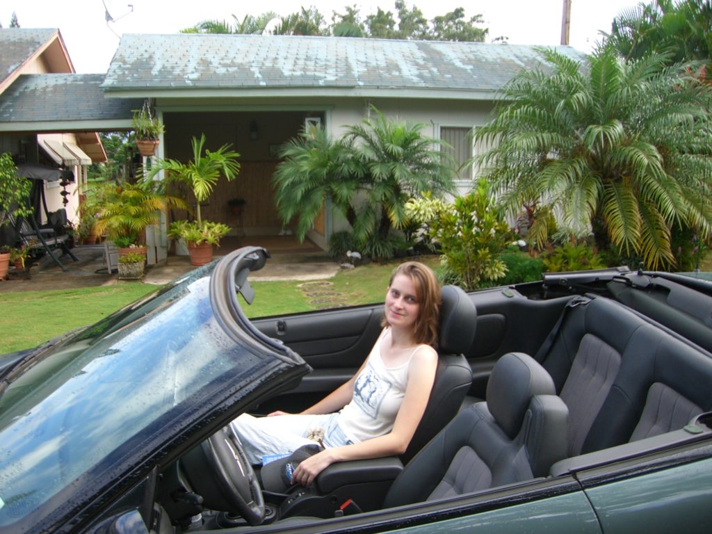 a woman sitting in a convertible car