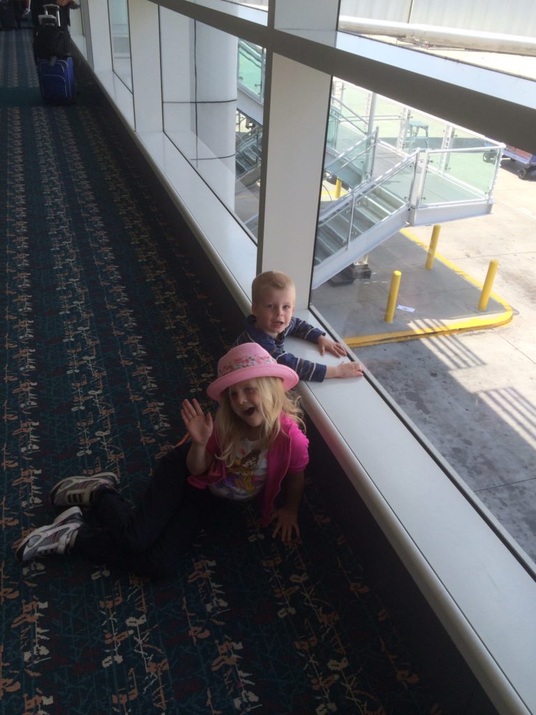a boy and girl sitting on the floor near a window