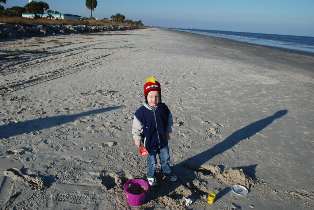 a boy standing on a beach