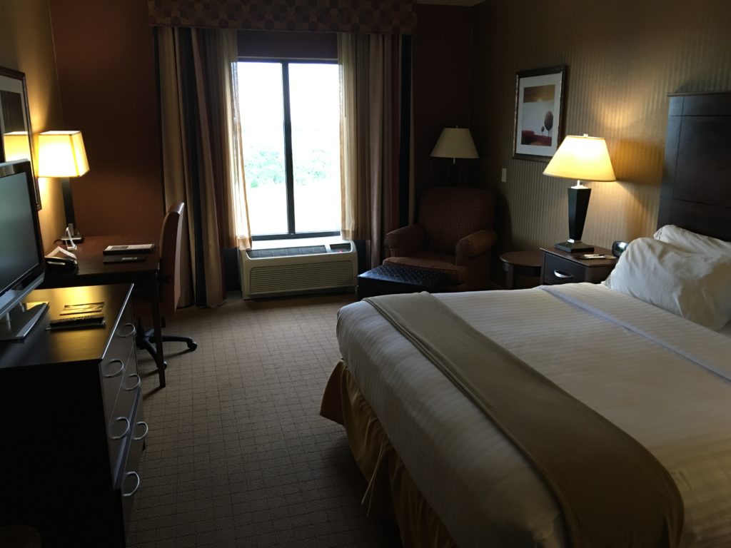a hotel room with a bed and a desk and a chair