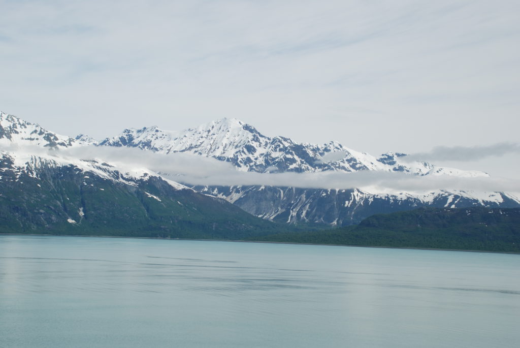 a body of water with snow covered mountains in the background