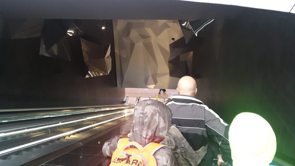 people walking down a escalator