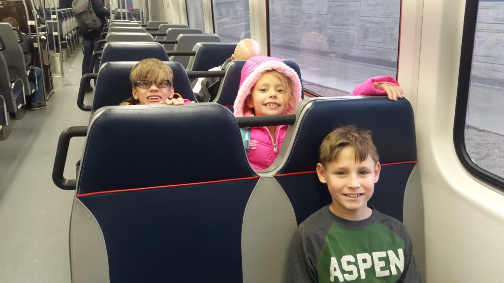 a group of kids sitting on a train