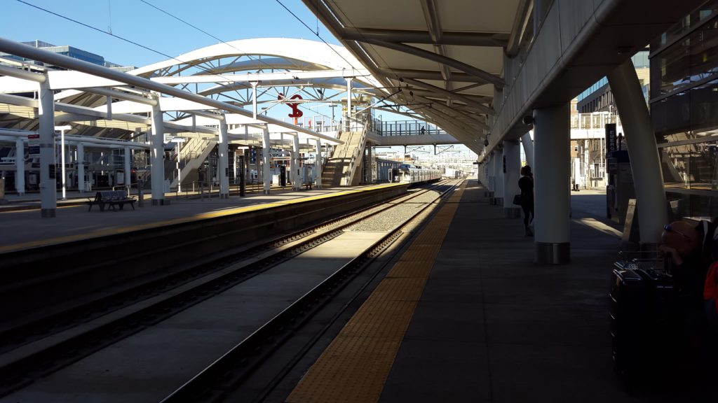 a train station with a platform and a person walking