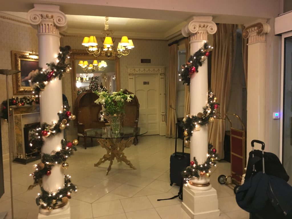 a room with white pillars decorated with lights and a glass table