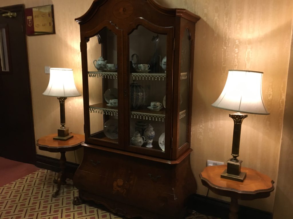a china cabinet with lamps in front of it