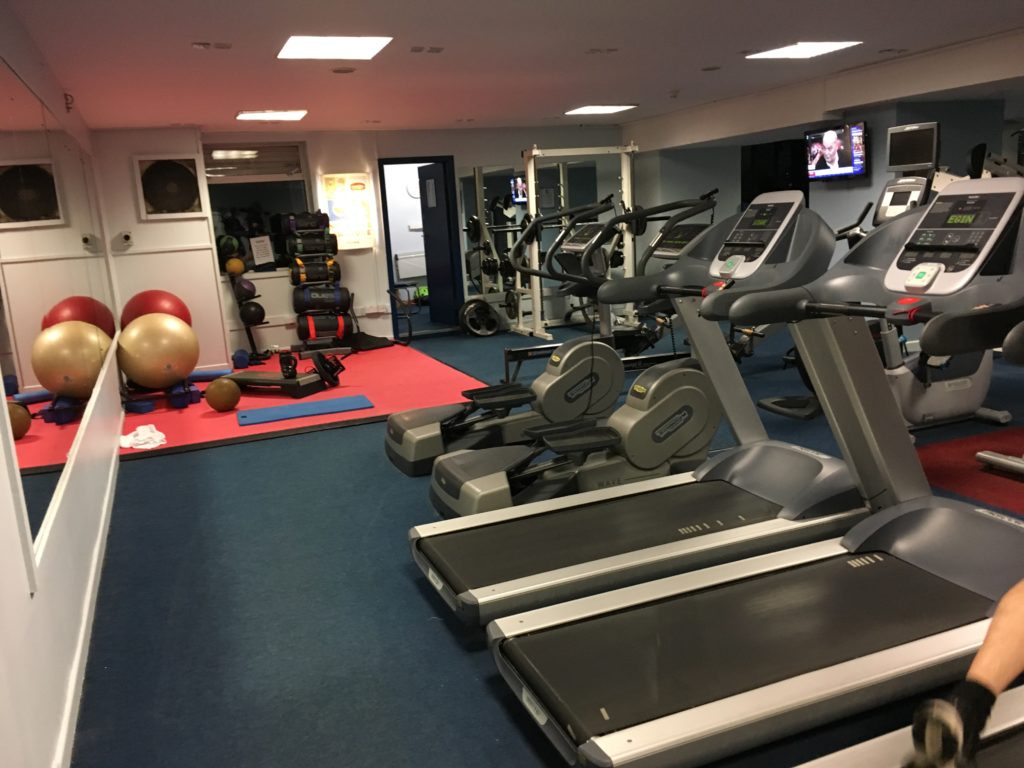 a room with exercise equipment and a large mirror