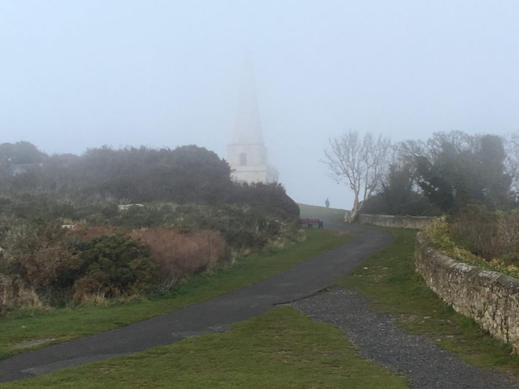 a path with a steeple in the distance