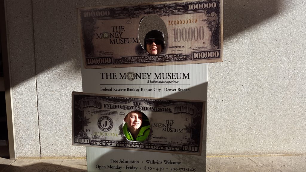 a man looking through a hole in a money sign