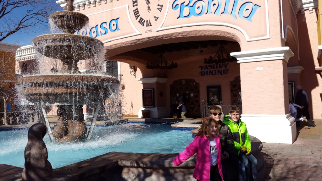 a group of people posing for a picture in front of a fountain