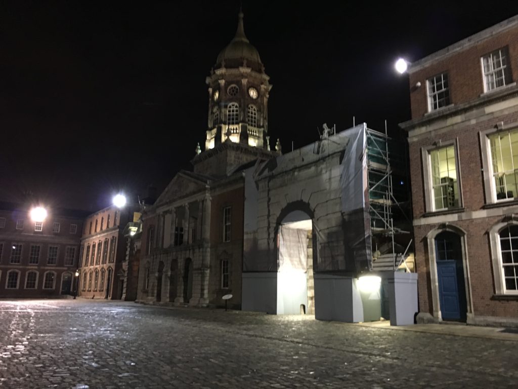 a stone street with a tower in the background