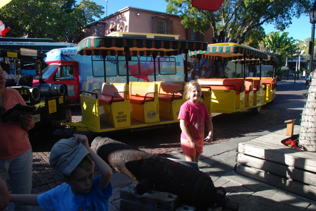a group of kids standing next to a train
