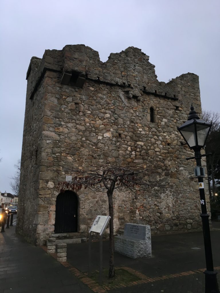 a stone building with a tree and a lamp post