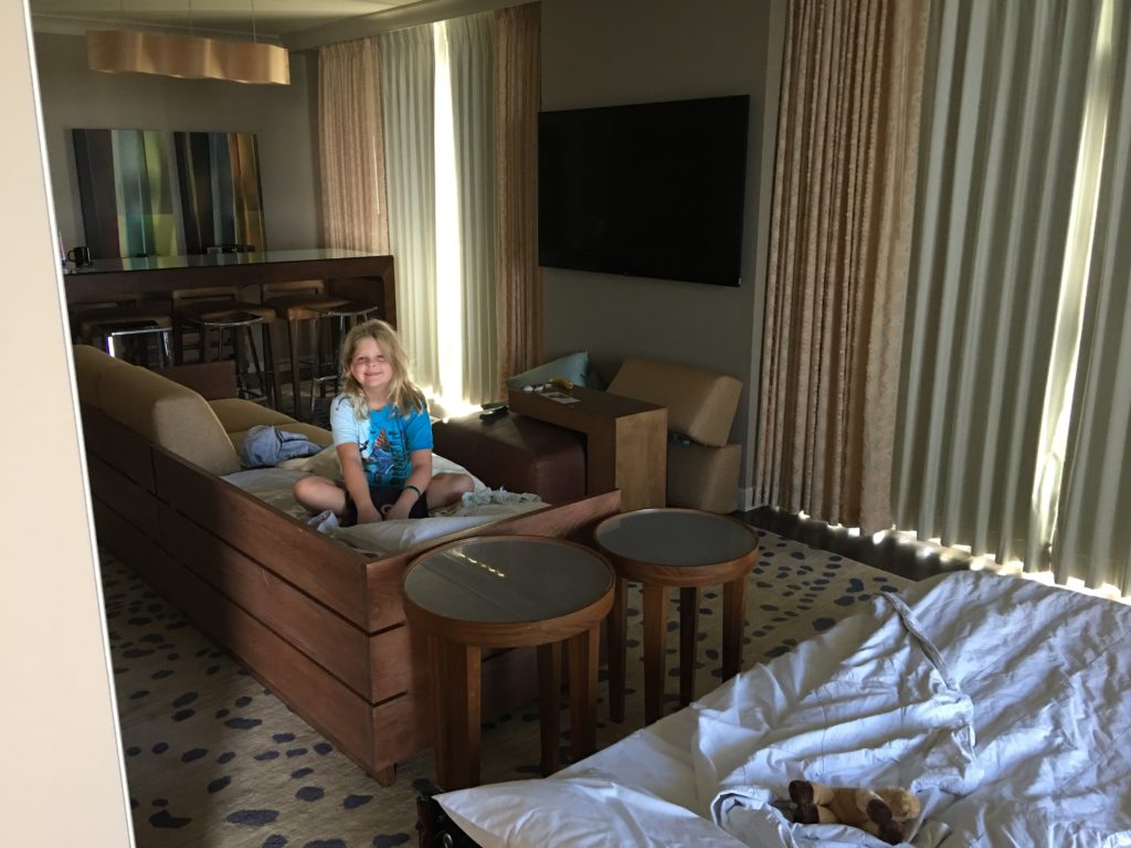 a girl sitting on a bed in a hotel room
