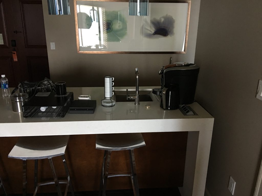 a counter with a sink and stools
