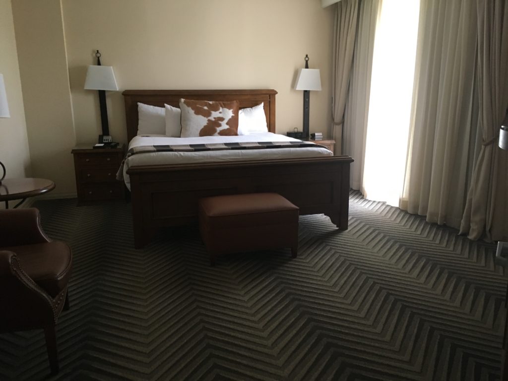 a bed with a brown and white pillow