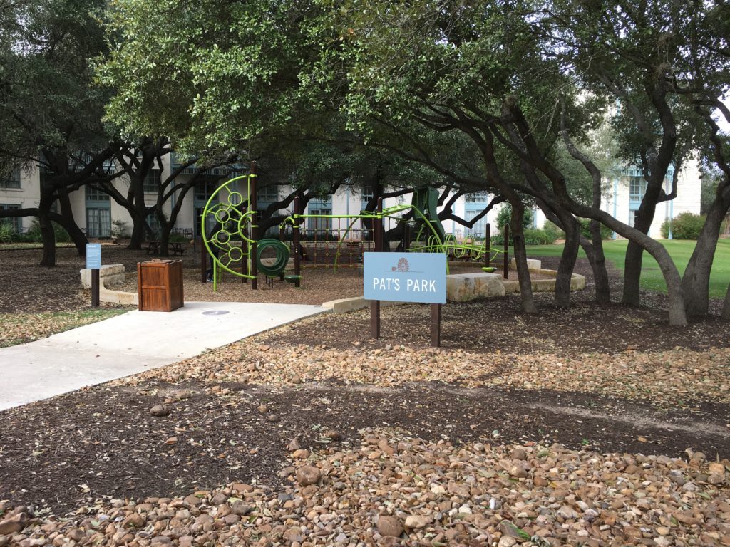 a playground with a sign and trees