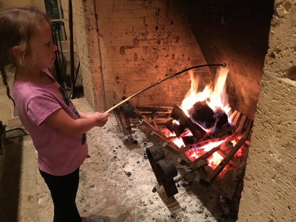 a girl holding a stick over a fire