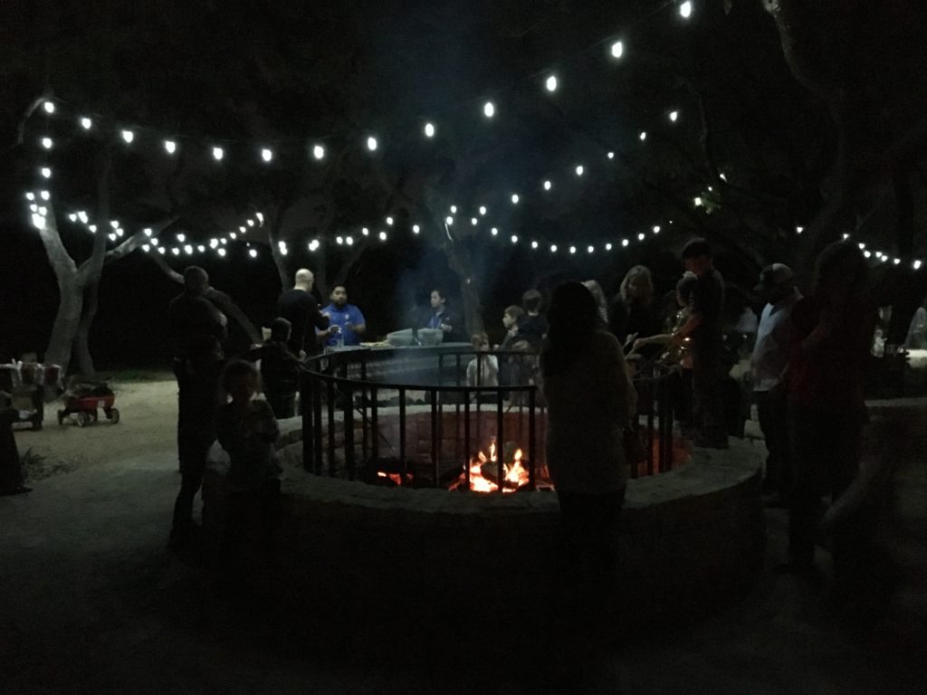 a group of people around a fire pit