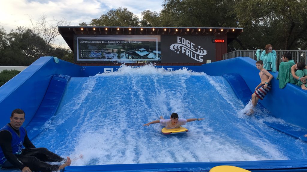 a boy on a boogie board in a water park