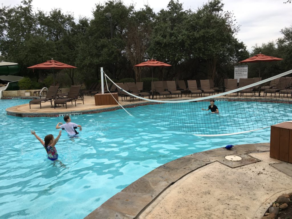 a group of kids playing in a pool