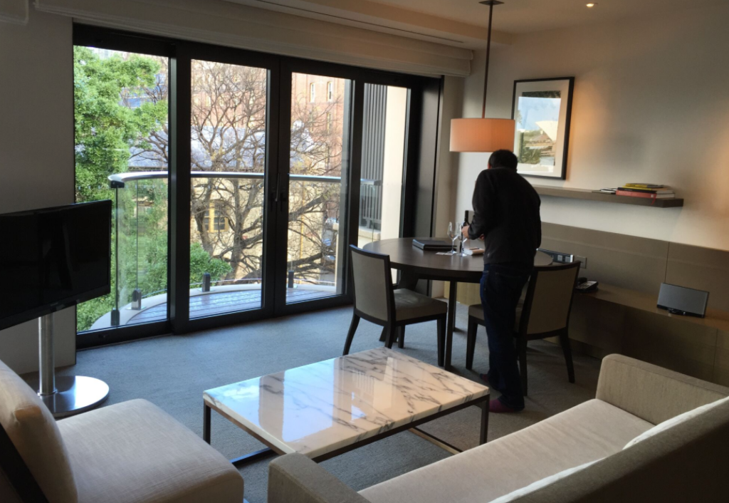 a man standing at a table in a room with glass doors