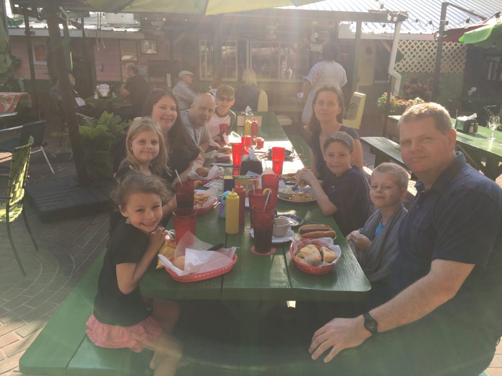 a group of people sitting at a table with food