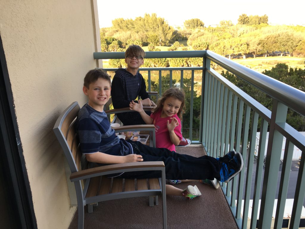 a group of kids sitting on a balcony