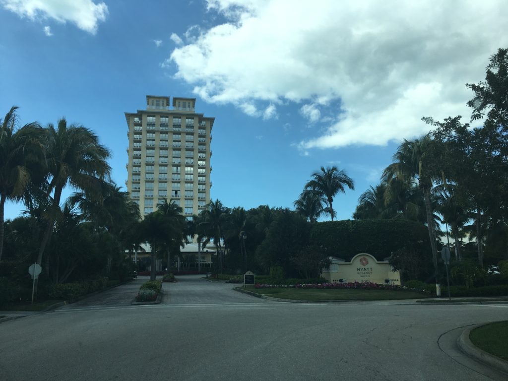 a building with palm trees and a road