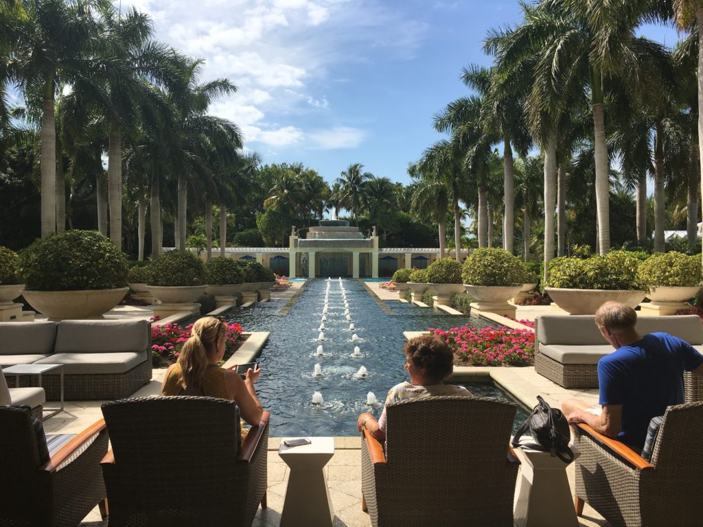 a group of people sitting in chairs in front of a water fountain