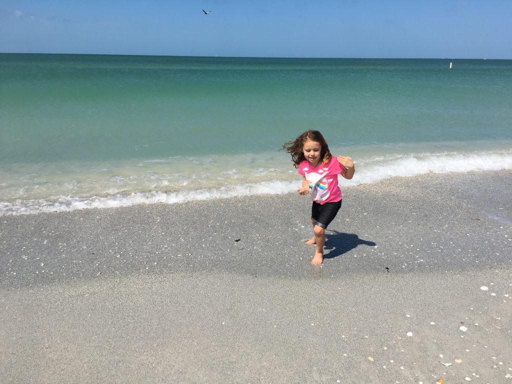 a girl running on a beach