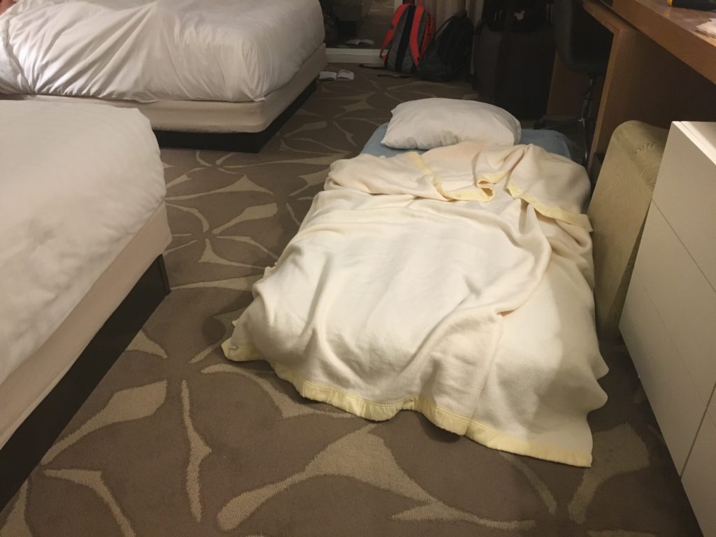 a bed with a blanket on the floor