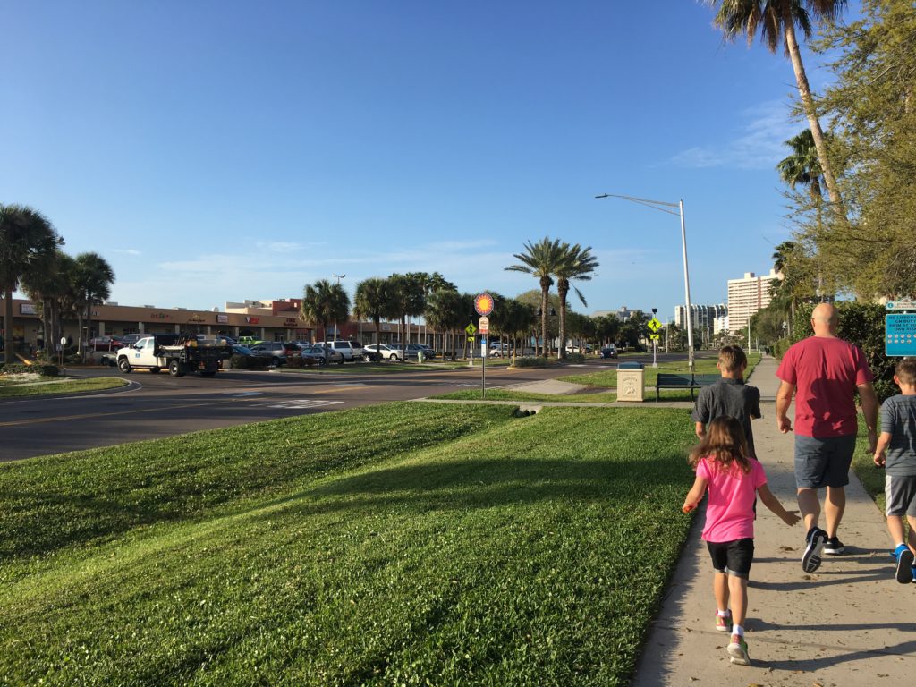 a group of people walking on a sidewalk