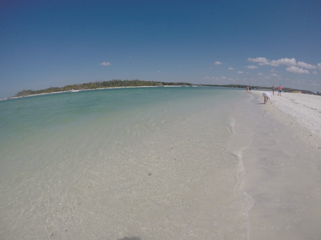 a beach with people walking on the sand
