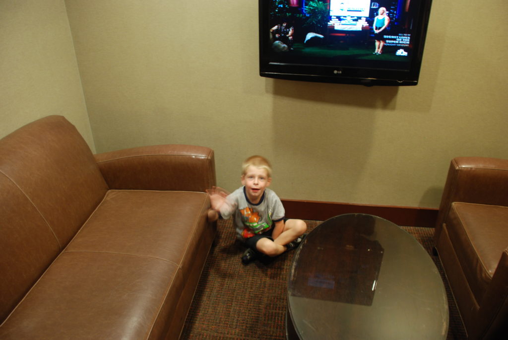 a boy sitting on the floor in front of a television