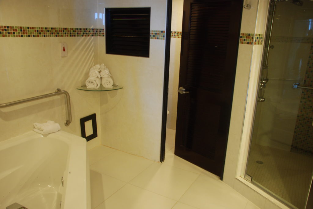 a bathroom with a glass shelf and a bathtub