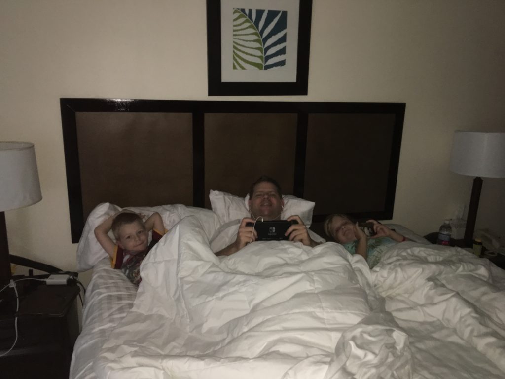 a man and two children lying in a bed