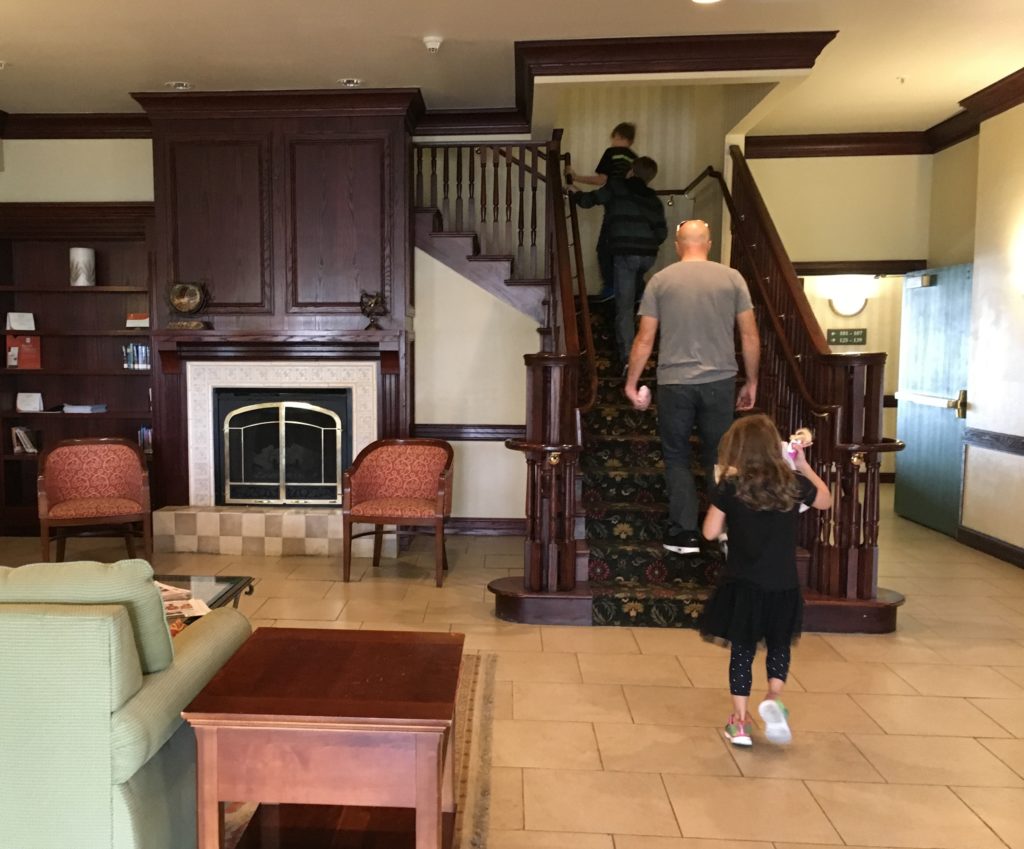 a man and child walking up the stairs in a house