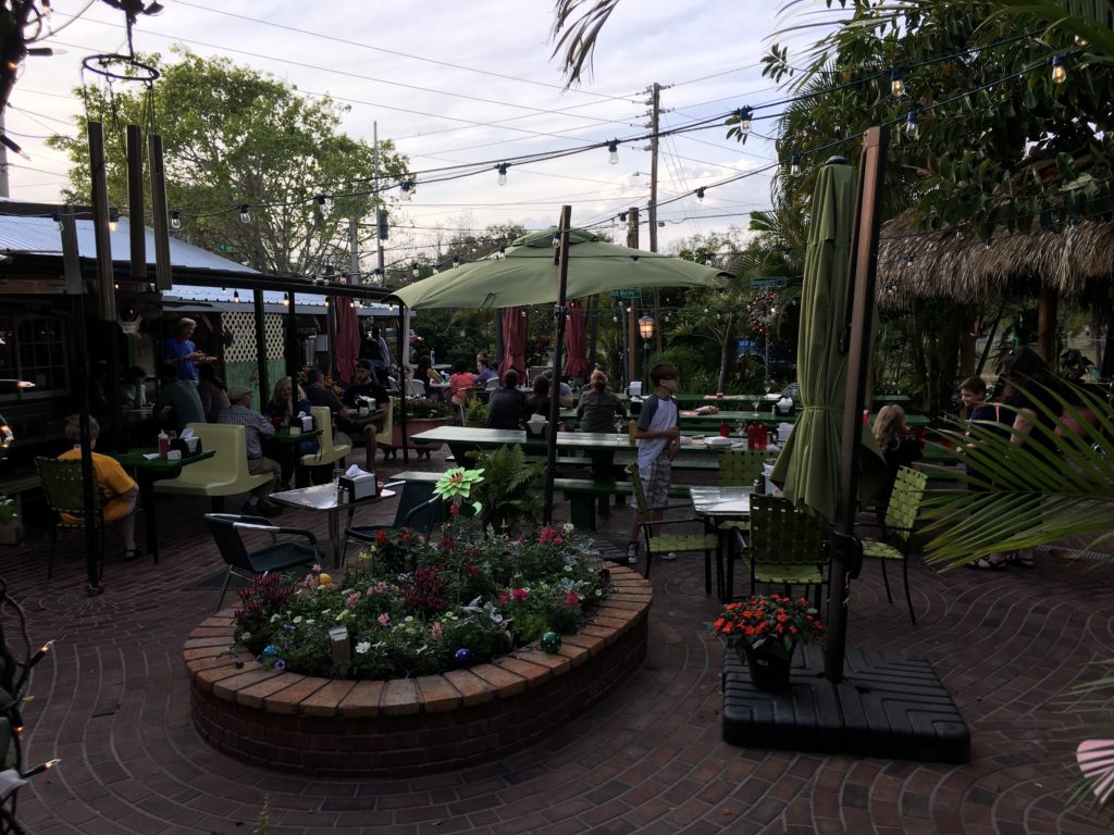 a group of people sitting at tables and chairs