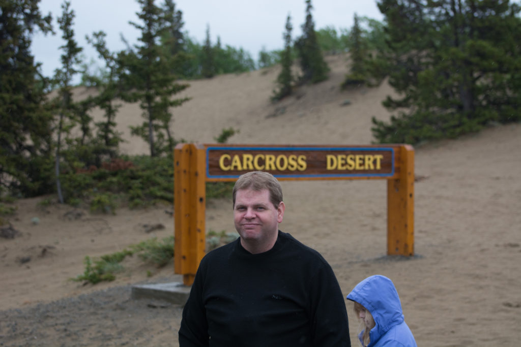 a man and child standing in front of a sign