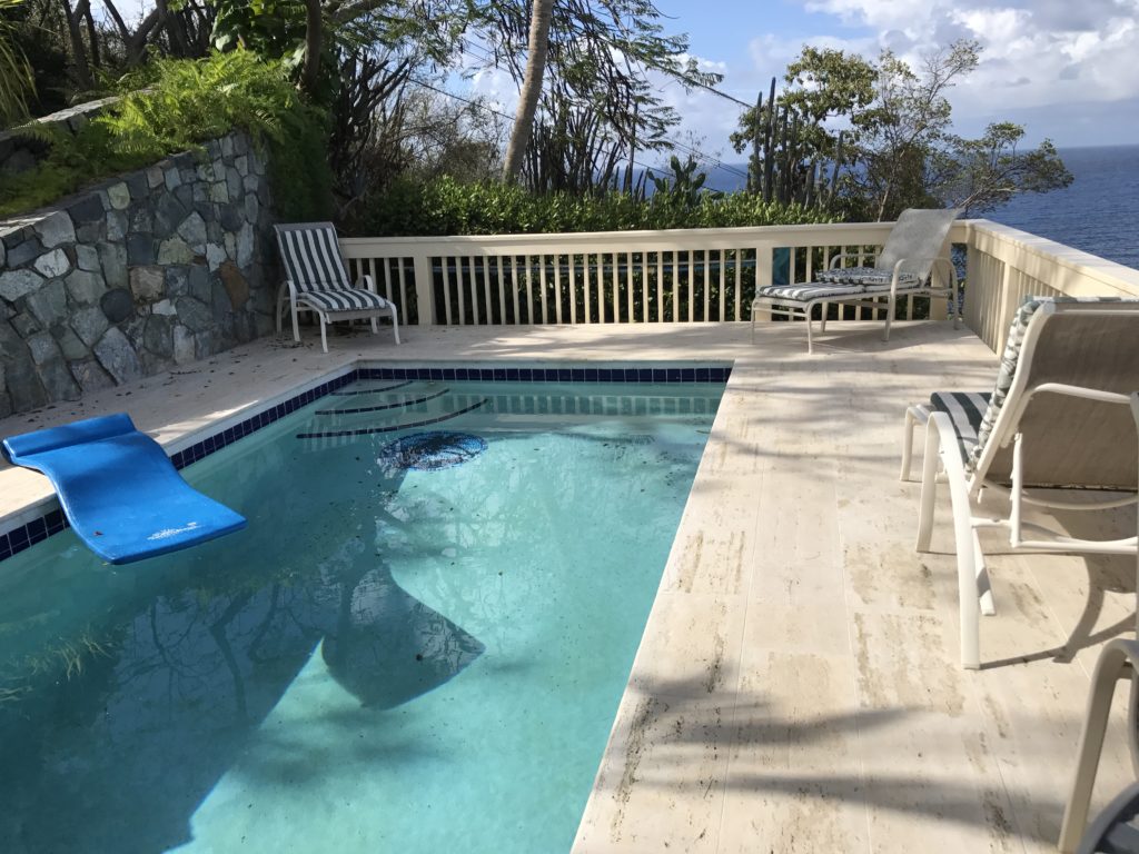 a swimming pool with a deck and chairs