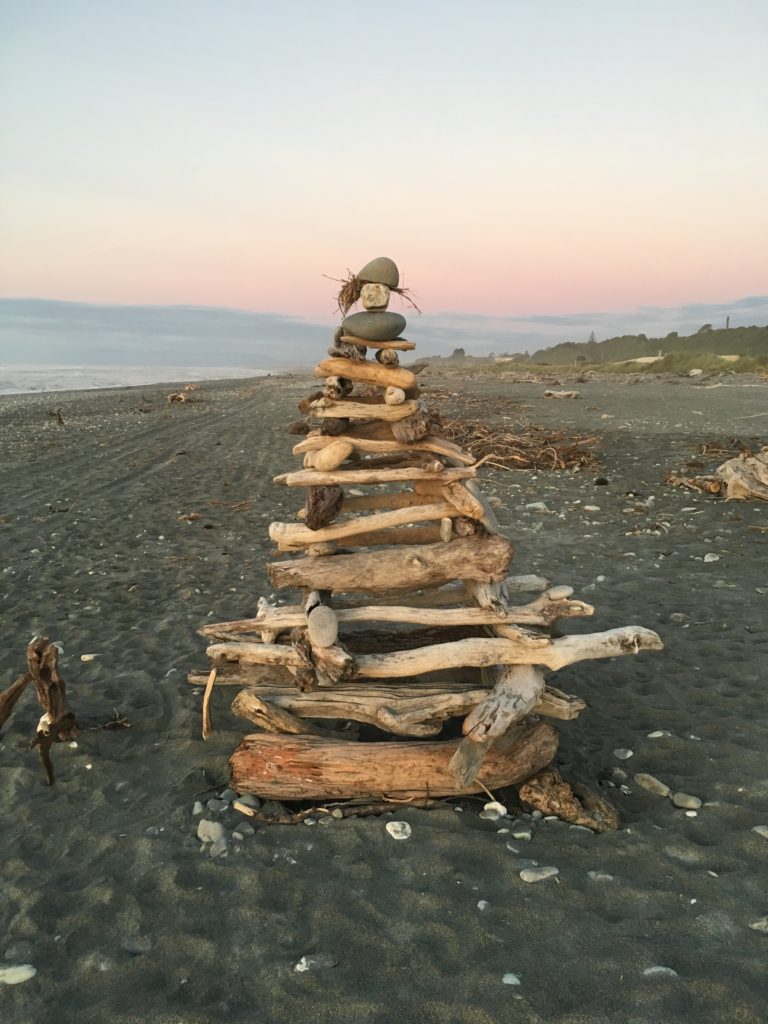 a stack of driftwood on a beach