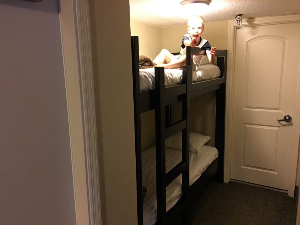 a child lying on a bunk bed