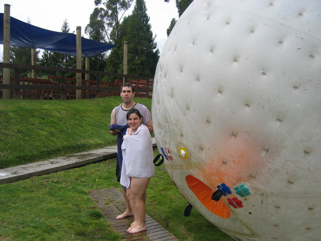 a man and woman standing next to a large inflatable ball