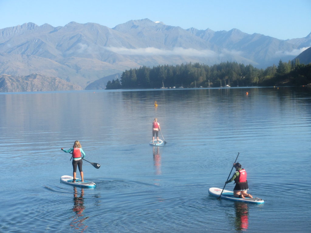 a group of people on paddle boards on a lake