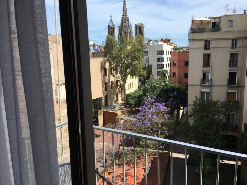 a balcony with a tree and buildings in the background