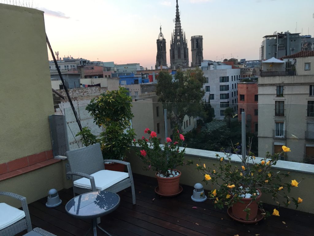 a balcony with a chair and a table and plants on it