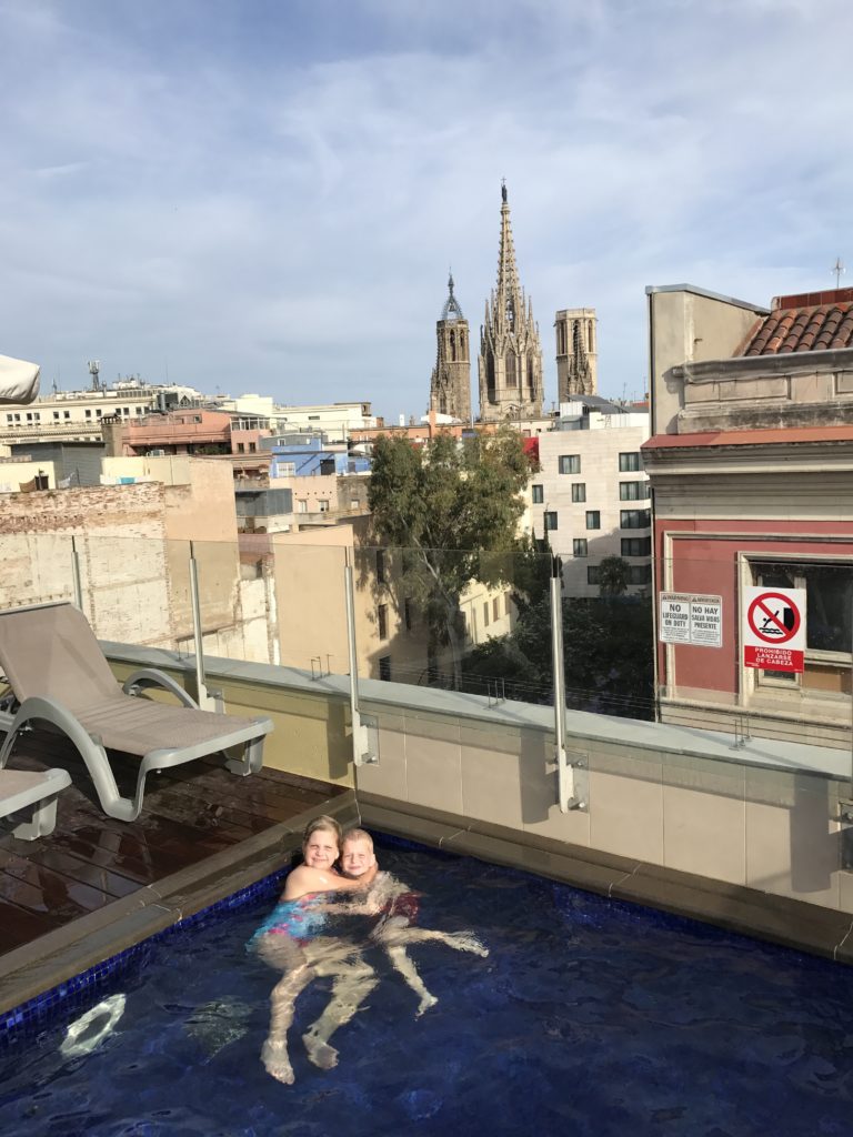 a woman and child in a pool with a city in the background
